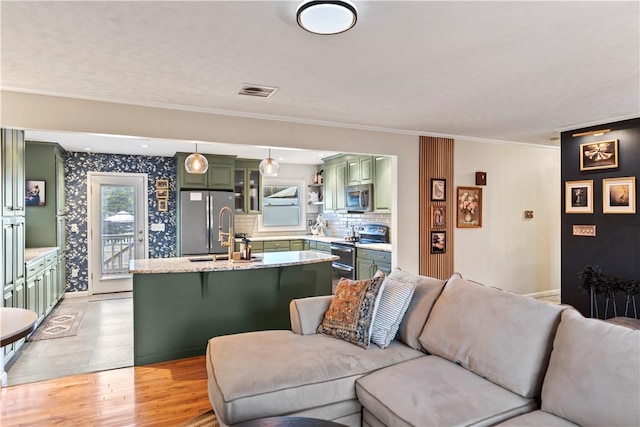 living room with visible vents, crown molding, and light wood finished floors