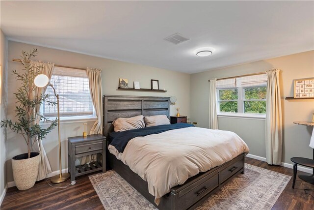 bedroom with baseboards, visible vents, and dark wood finished floors