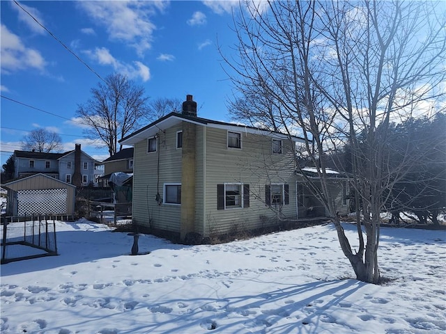 snow covered property with a chimney