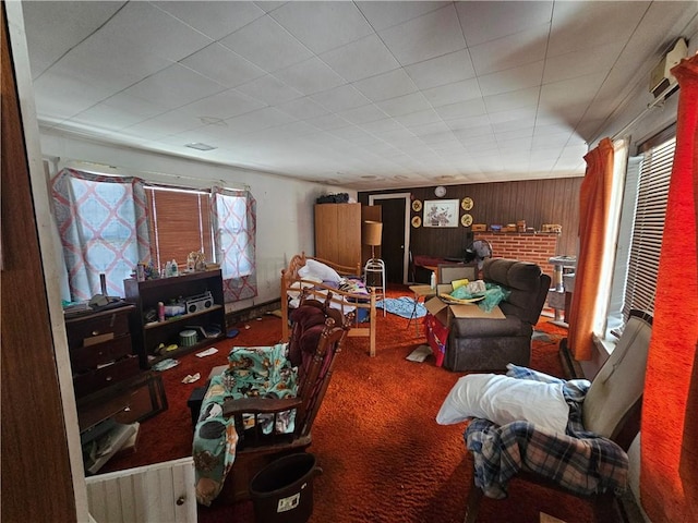 carpeted living area with wood walls