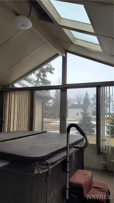 sunroom with lofted ceiling with beams and plenty of natural light