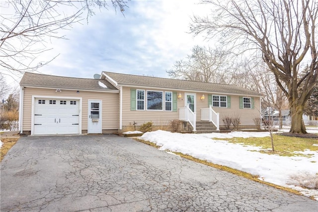 ranch-style house with a garage and aphalt driveway