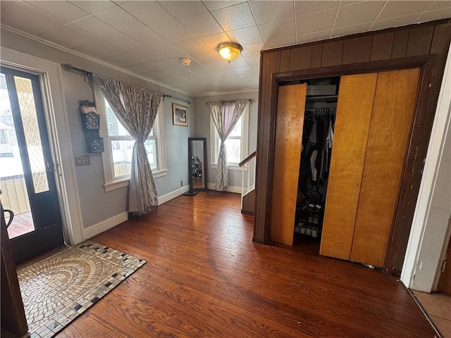 entrance foyer featuring stairway, crown molding, baseboards, and wood finished floors