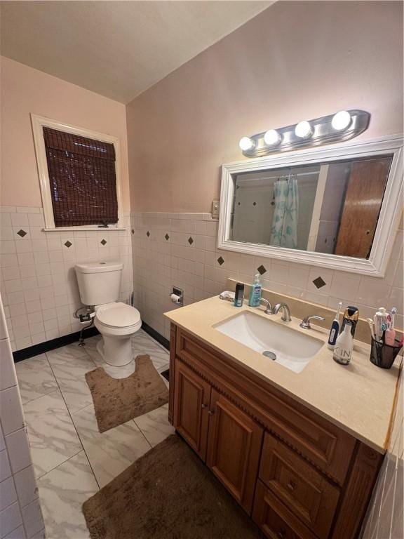 full bath with toilet, a shower with shower curtain, vanity, tile walls, and marble finish floor