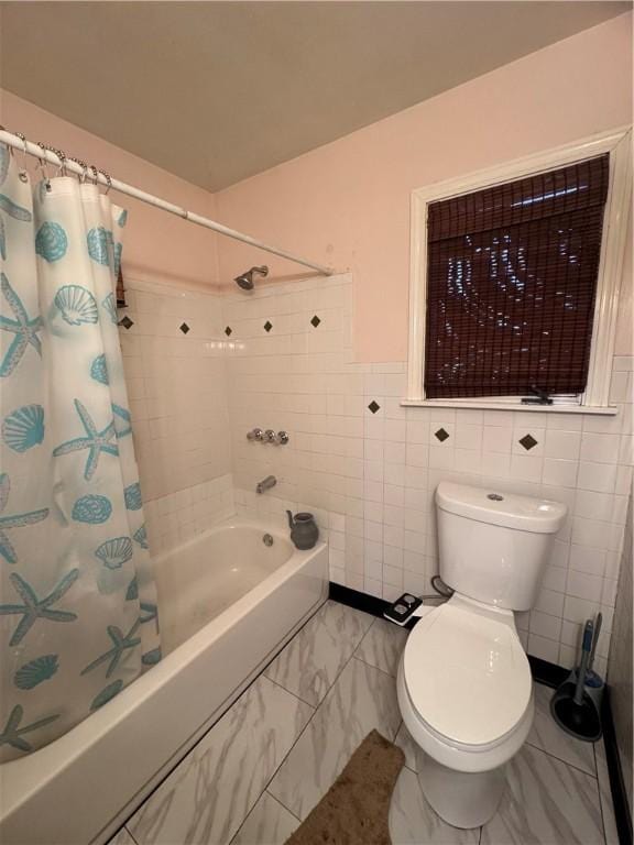 full bathroom featuring shower / tub combo, marble finish floor, toilet, and tile walls