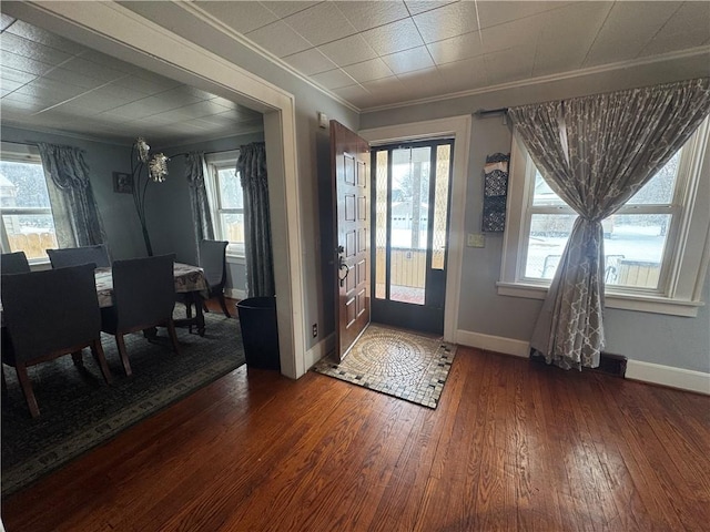 entryway with baseboards, hardwood / wood-style flooring, and crown molding