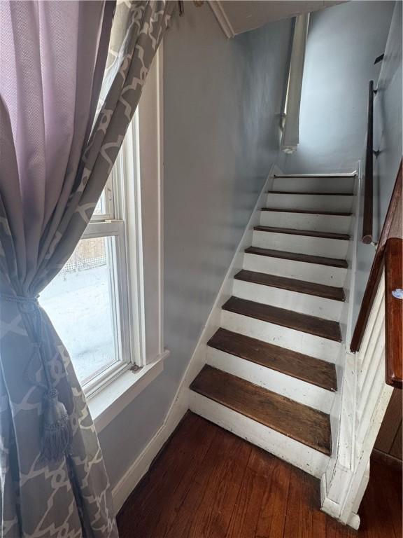 stairs featuring wood finished floors and baseboards