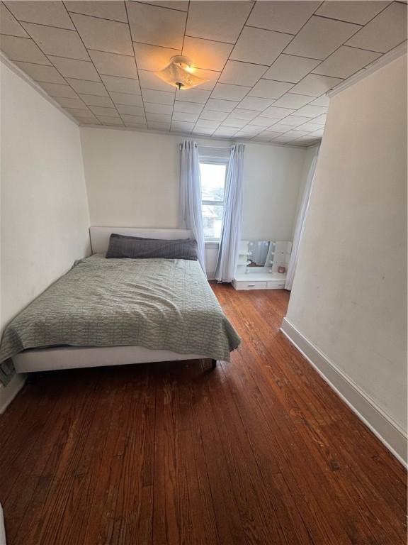 bedroom with baseboards and hardwood / wood-style flooring