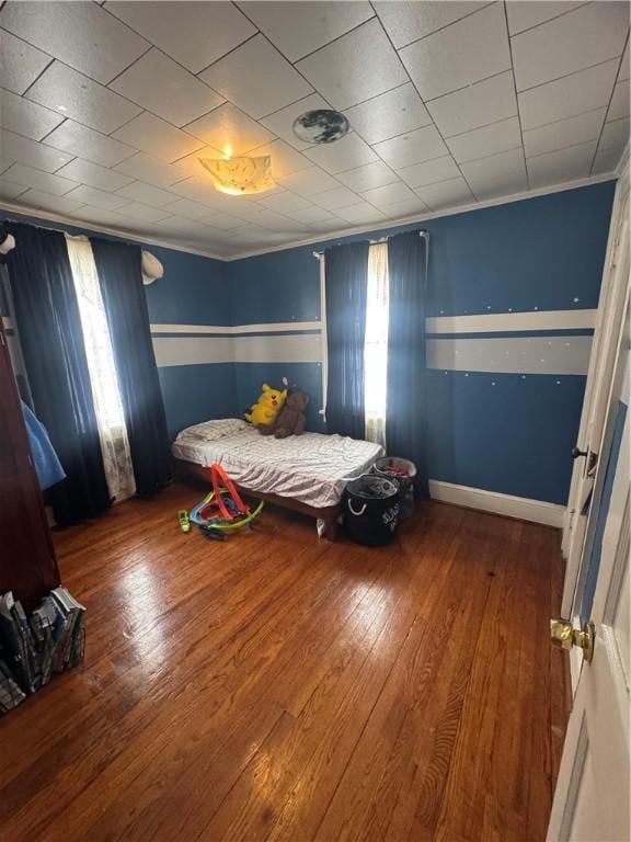 unfurnished bedroom featuring hardwood / wood-style flooring and crown molding