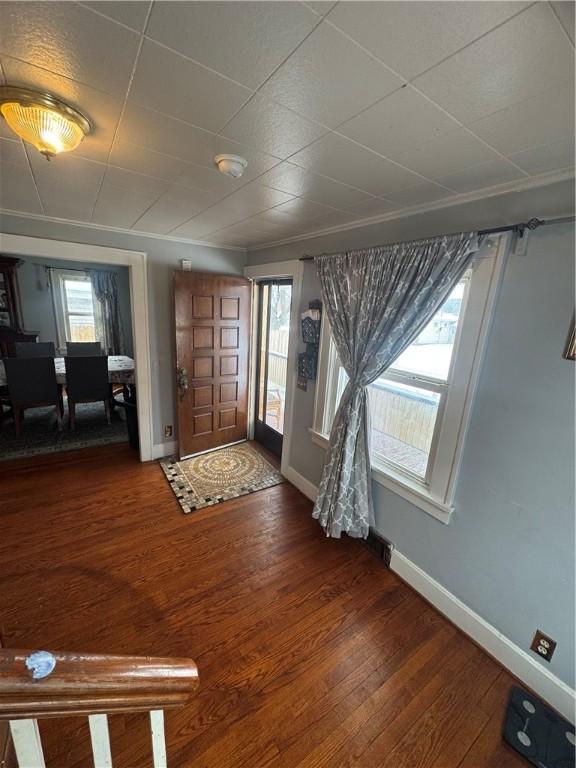 foyer with baseboards and wood finished floors