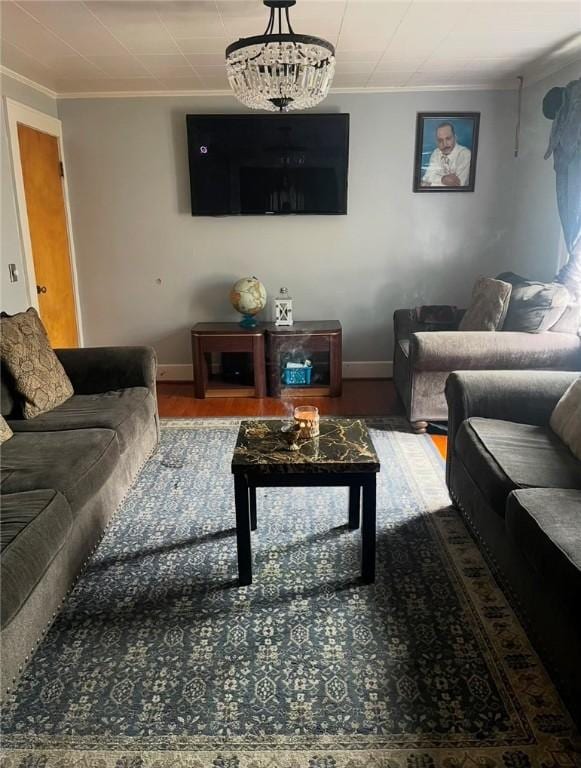 living area with crown molding, baseboards, and wood finished floors