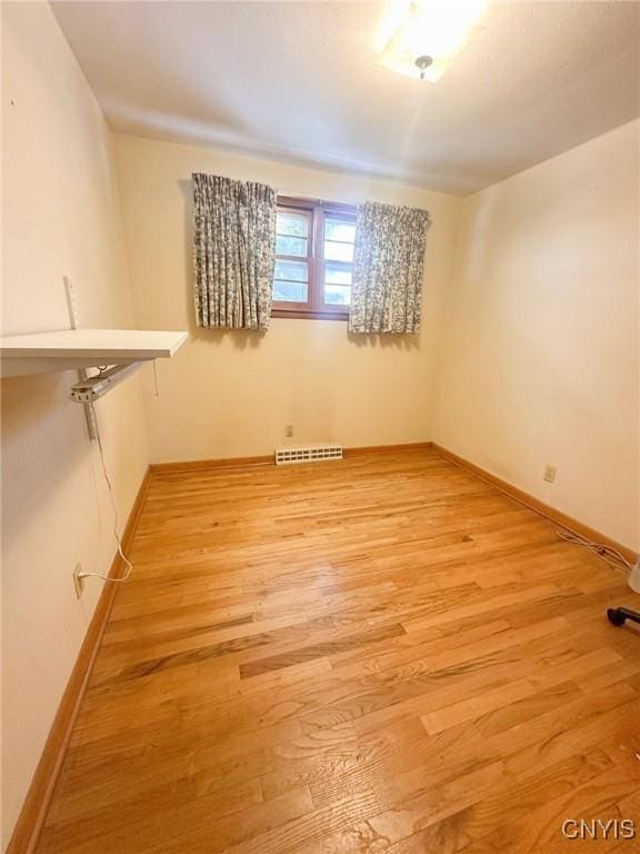 unfurnished room featuring light wood-style flooring, visible vents, and baseboards