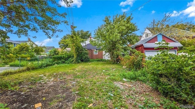 view of yard featuring a garage and fence