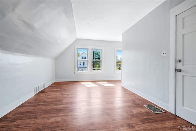 bonus room featuring vaulted ceiling, wood finished floors, visible vents, and baseboards