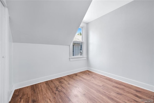 bonus room featuring lofted ceiling, baseboards, and wood finished floors