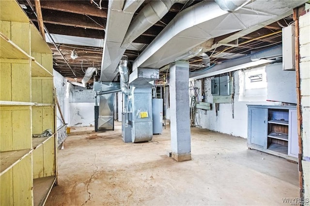 unfinished basement featuring electric panel, water heater, and heating unit