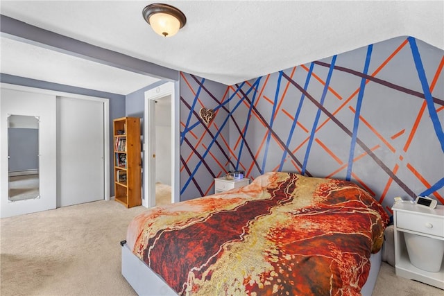 bedroom featuring an accent wall, carpet, a closet, and wallpapered walls