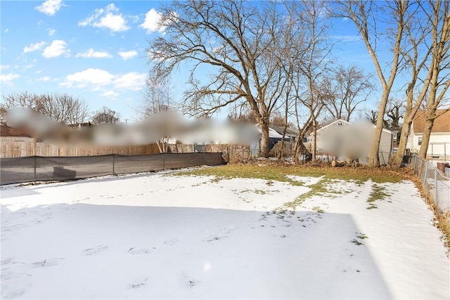 yard layered in snow featuring a fenced backyard