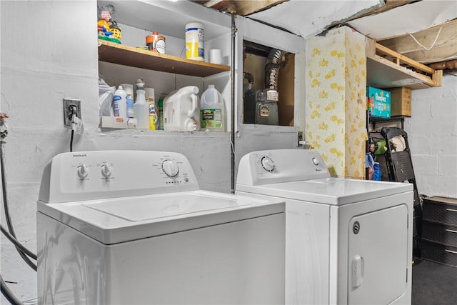 laundry room with washing machine and dryer, laundry area, and concrete block wall