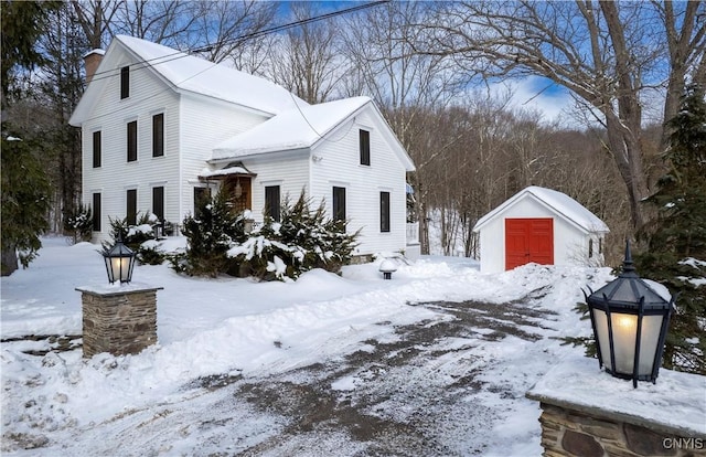 view of snow covered exterior with an outbuilding