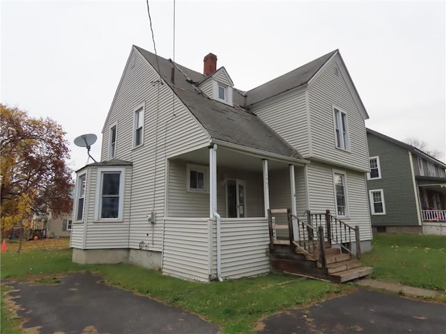 view of front of house featuring a porch and a chimney