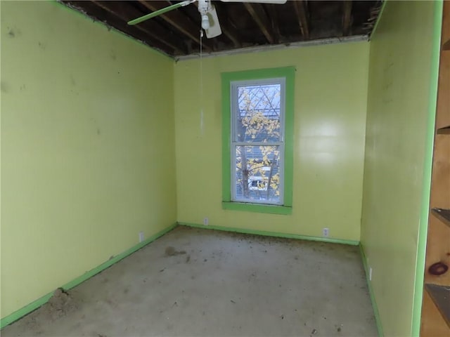 unfurnished room featuring baseboards and unfinished concrete floors