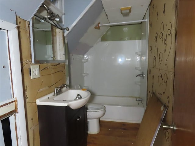 bathroom with washtub / shower combination, vanity, toilet, and wood finished floors