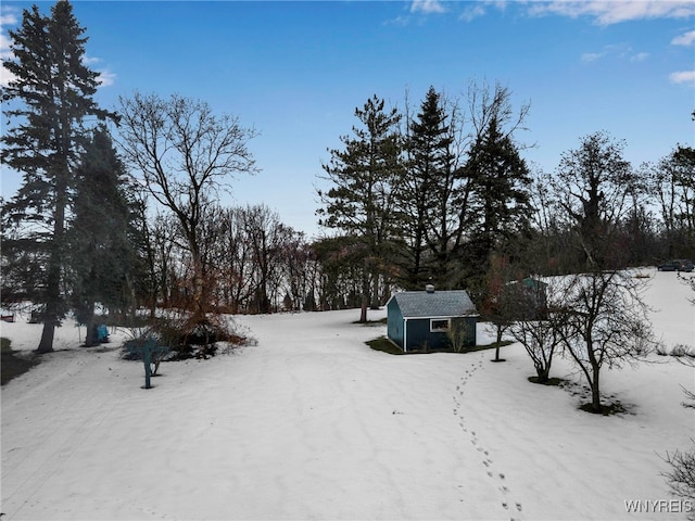 yard layered in snow featuring an outdoor structure