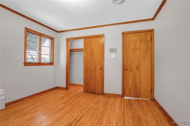 unfurnished bedroom with ornamental molding, a closet, baseboards, and light wood finished floors