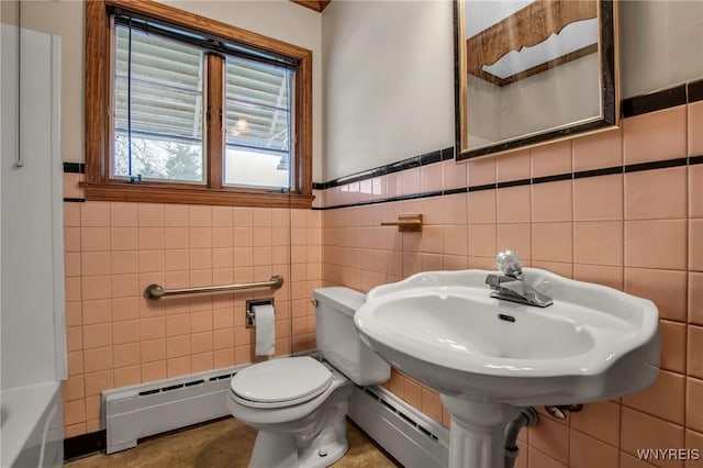 bathroom featuring a baseboard heating unit, a sink, toilet, and tile walls