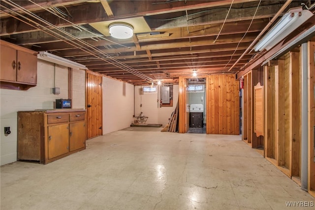 basement with light floors and electric panel