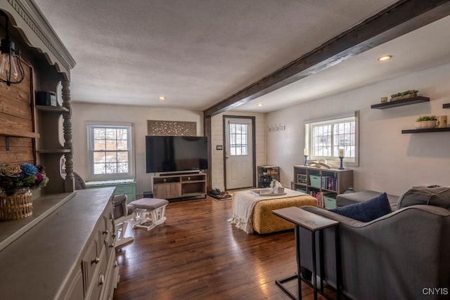 living area featuring a wealth of natural light, recessed lighting, dark wood-type flooring, and beamed ceiling