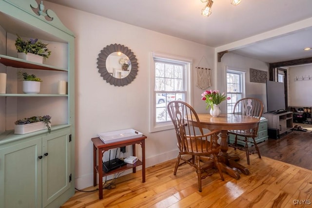 dining space featuring light wood-style flooring and baseboards