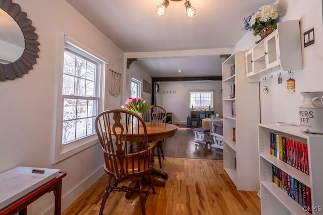 dining space featuring light wood finished floors and baseboards