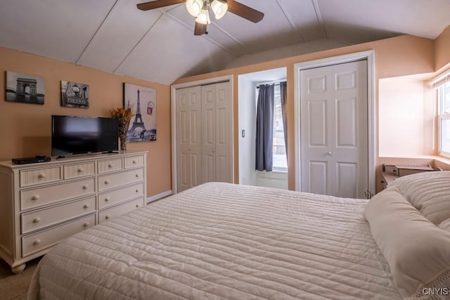 bedroom with lofted ceiling, ceiling fan, and multiple closets