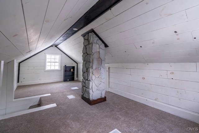 additional living space with carpet floors, wooden ceiling, vaulted ceiling, and wooden walls