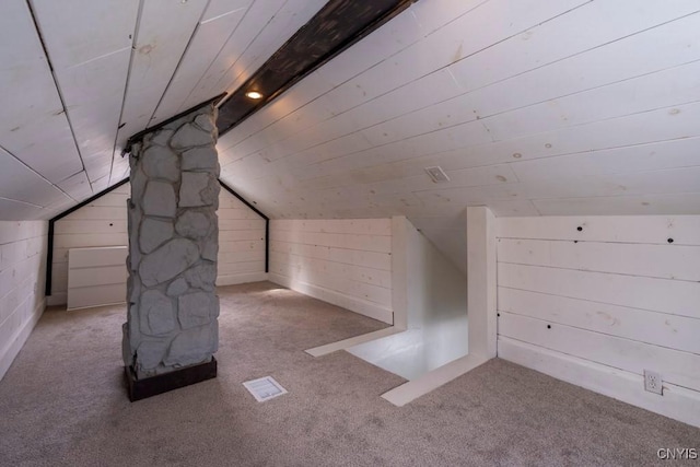 bonus room with lofted ceiling, carpet, and wooden walls