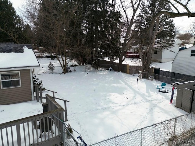 snowy yard with a fenced backyard