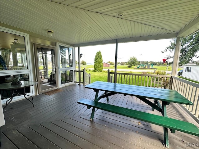 deck featuring a lawn and a playground