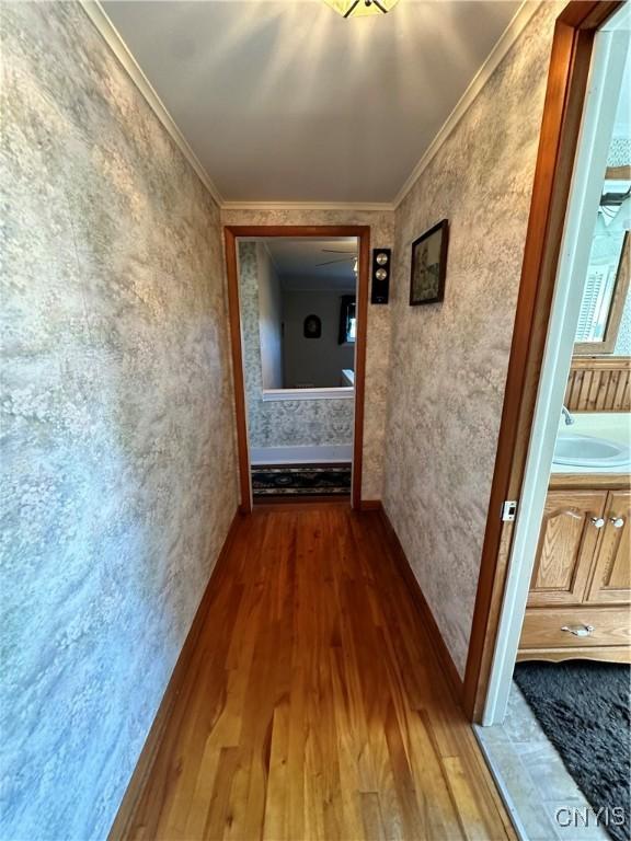 corridor featuring ornamental molding and wood finished floors