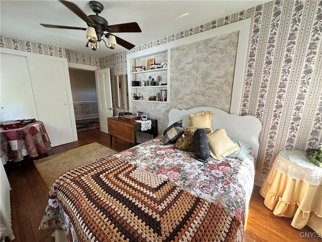 bedroom featuring ceiling fan, wood finished floors, and wallpapered walls