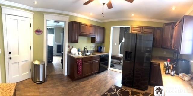 kitchen with black appliances, ornamental molding, light countertops, and dark wood finished floors