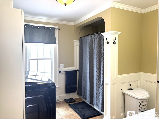 full bath with washer / clothes dryer, a wainscoted wall, and crown molding