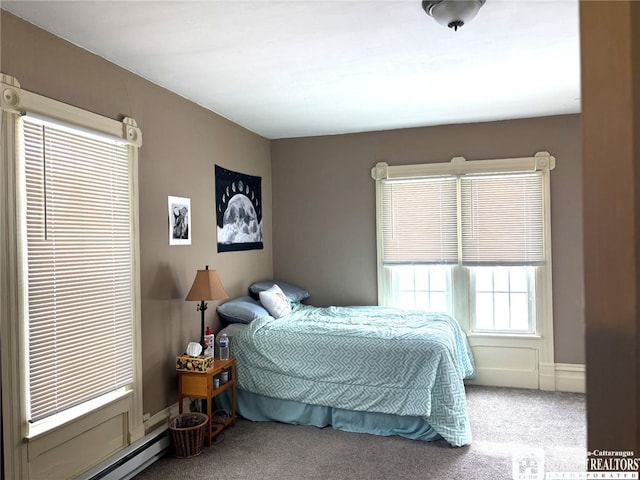 carpeted bedroom with baseboard heating and baseboards