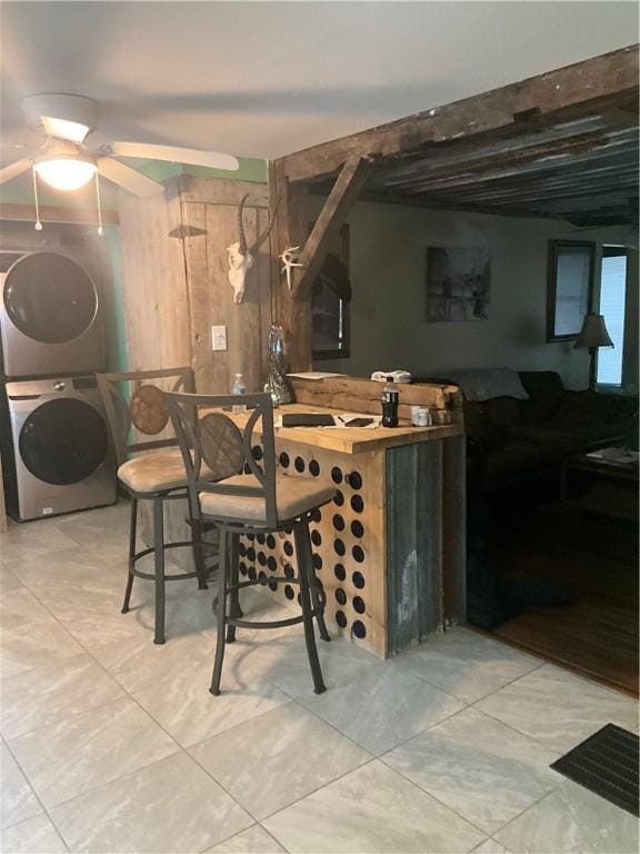 bar featuring stacked washer and dryer and ceiling fan