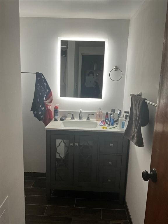 bathroom featuring wood tiled floor, vanity, and baseboards