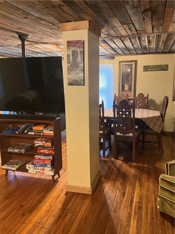 dining space featuring wood-type flooring, wood ceiling, and baseboards