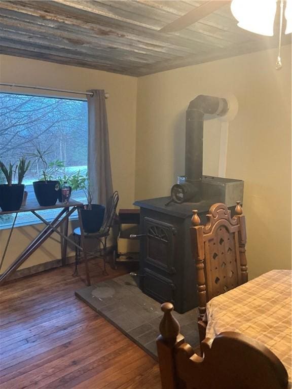 bedroom with a wood stove and hardwood / wood-style floors