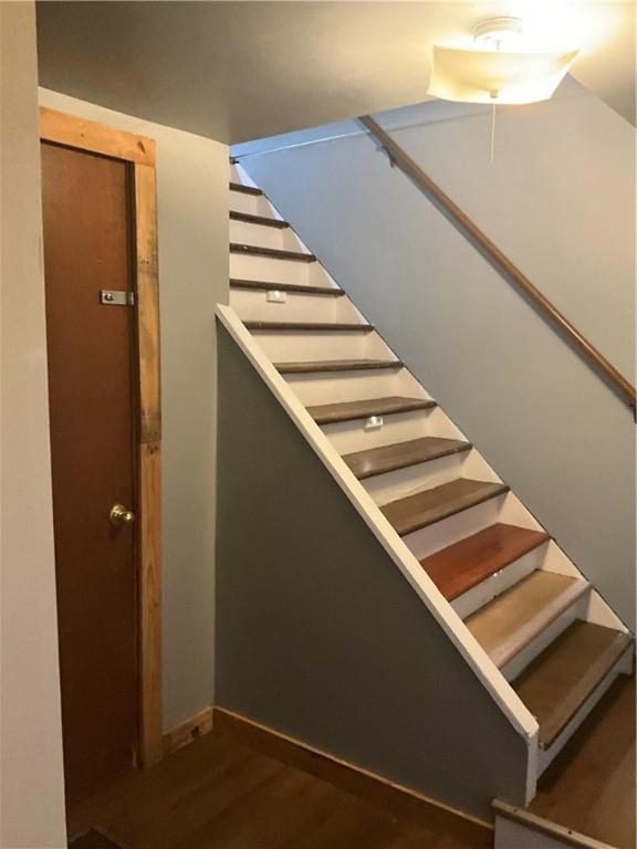 staircase with baseboards and wood finished floors