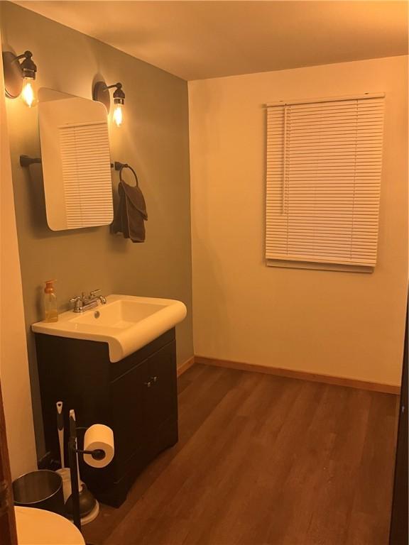 bathroom featuring toilet, wood finished floors, vanity, and baseboards